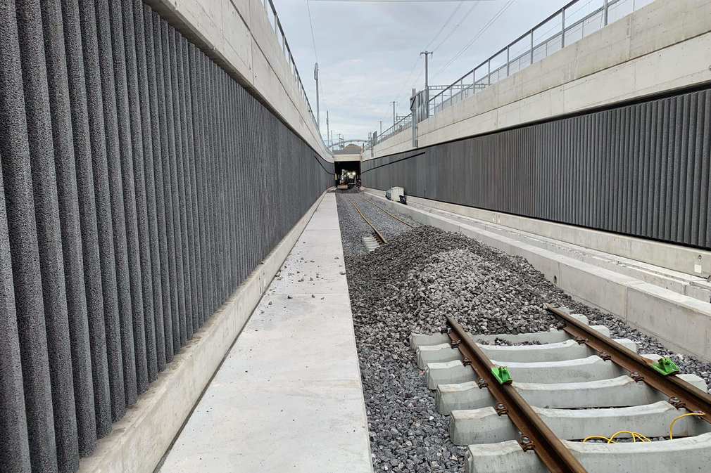 Einschottern-Gleisrost-Tunnelrampe-mit-ZweiwegebaggerGleisschotter-aus-Zwischenlagerung-einbringen